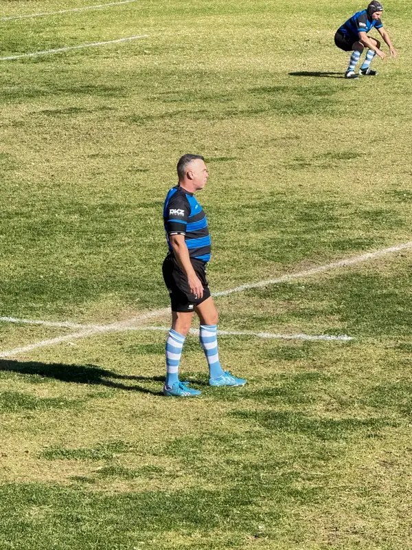 Jugador de Tango Classic's en el campo con la camiseta azul y negra y medias celestes